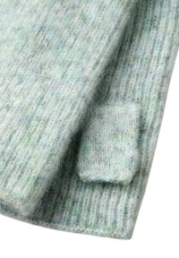 Pletený šál ve světle zelené barvě s různými odstíny a měkkým, texturovaným povrchem. Obsahuje žebrovaný vzor a malý kapsičkový detail.