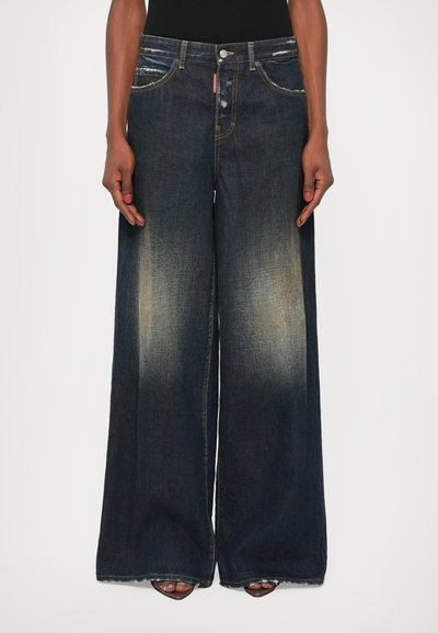 Bredbensede denim jeans i mørkeblå med en falmet vask, der har fem lommer, en knaplukning og frynsede kanter.