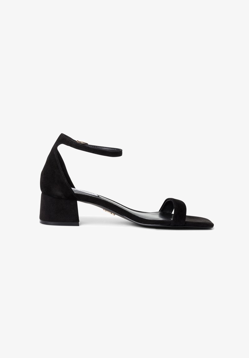 Sandale à talon en daim noir avec un bout carré, une bride de cheville et un talon épais. Texture lisse et design minimaliste.