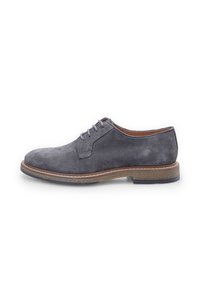 Scarpe derby in suede grigio con punta tondeggiante, sei occhielli per i lacci e suola in contrasto marrone. Texture liscia e dettagli di design minimalisti.
