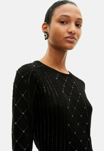Zwart gebreide trui met verhoogde diamanten patronen met kleine ingebedde kralen, ronde halslijn en lange mouwen.