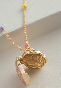 Kuldne ripats-locket kaelakee, millel on värvilised helmed (roosa, kollane, lilla) ketil; lillemuster locketi esiküljel; tekstureeritud sisemus.