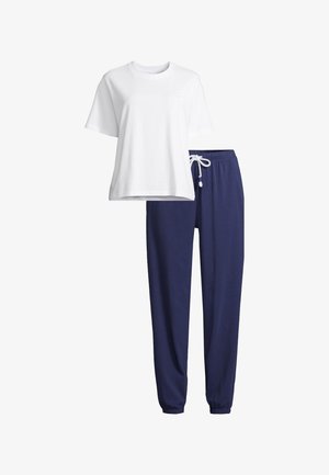 Wit T-shirt met korte mouwen en een kleine lichtroze smiley op de borst, gecombineerd met marineblauwe joggerbroek met elastische taille en witte trekkoord.