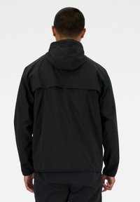 Sort hættejakke med elastiske manchetter, rygstykke og et slankt, let design. Mat finish med en glat tekstur.