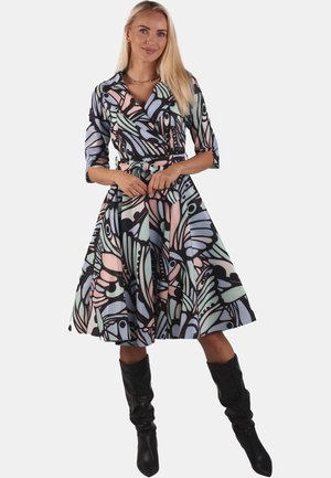 Schwarz-weißer Wickelkleid mit floralem Muster, ausgestattet mit sanften pastellfarbenen Blättern, Dreiviertelärmeln und tailliertem Gürtel. Knielanger, ausgestellt gestalteter Rock.