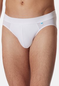 Witte katoenen slip met een brede tailleband en een klein blauw logo, een gladde textuur en een aansluitende pasvorm die ontworpen is voor comfort.