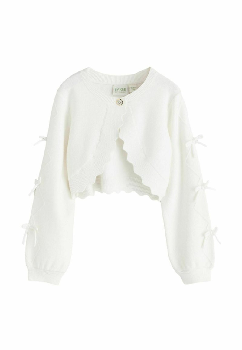 Baltas trumpintas kardiganas su banguotais kraštais, sagų užsegimu, ilgomis rankovėmis su susirišimais ir minkštu megztu audiniu.