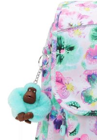 Blommönstrad ryggsäck i rosa, grön och blå, med en fluffy teal gorillasnyckelring. Material: tyg med en slät textur.