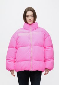 Ružová nadýchaná bunda s vysokým golierom, zapínaním na zips, nadrozmerným strihom, lesklým povrchom a prešívanými panelmi pre izoláciu.