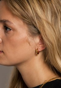 Gul hoopsøgelys og lille lynbolt-studsøgelys sat sammen. Glat, skinnende overflade; hoopen er større med et afrundet design.