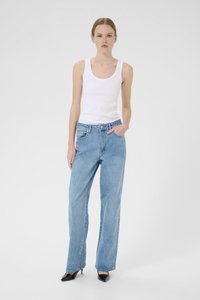 Lyseblå, løstsittende denimjeans med middels høy midje, frontlommer og subtil falming. Sammen med en hvit tanktop og svarte hæler.