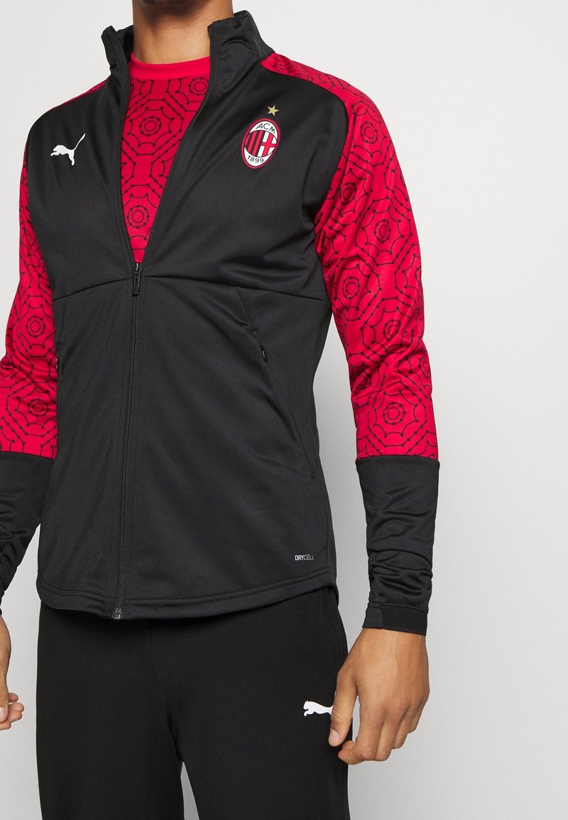 Black athletic jacket with red patterned sleeves, featuring a front zipper, logo, and "DRYCELL" branding at the hem.