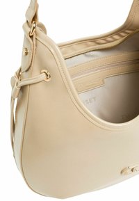 Borsa in pelle beige con forma arrotondata, hardware dorato e una tasca interna con zip. L'interno foderato presenta il nome del marchio, "TWINSET."