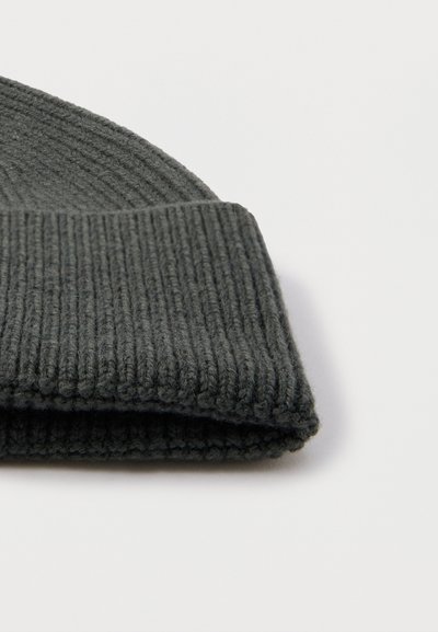 Bonnet gris tricoté avec un large bord côtelé. Fabriqué à partir d'un matériau doux, présente une surface texturée légèrement duveteuse.