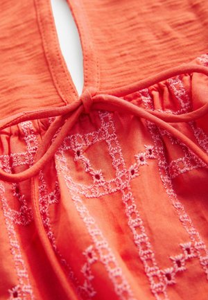 Coral fabric top with embroidered floral patterns in light pink. Features a keyhole neckline and gathered detail at the waist.