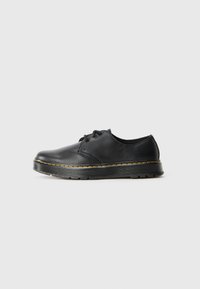 Black leather lace-up shoe with a rounded toe and yellow stitching along the sole. Features a textured rubber outsole for grip.
