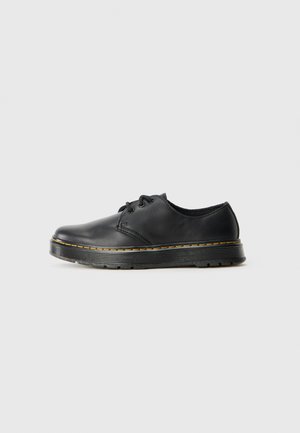 Black leather lace-up shoe with a rounded toe and yellow stitching along the sole. Features a textured rubber outsole for grip.