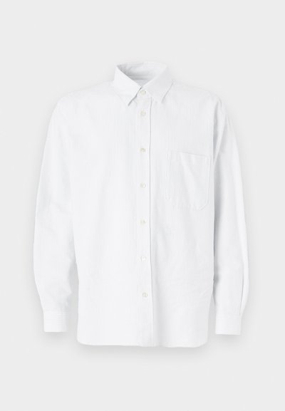Camisa blanca de botones con cuello, con sutiles rayas verticales, mangas largas, un bolsillo en el pecho y un dobladillo redondeado clásico.