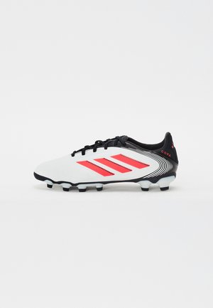 Crampon de football blanche avec des accents noirs, présentant trois rayures rouges sur le côté, un design texturé et une semelle noire avec des points de traction en relief.
