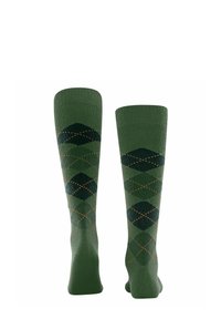 Calze verdi al ginocchio con un motivo argyle composto da rombi verde scuro e verde chiaro, arricchite da piccoli punti arancioni.