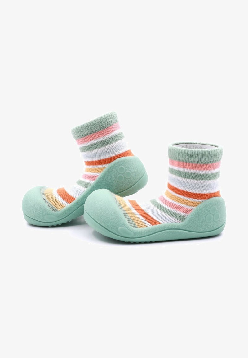 Zapatillas de goma verdes con un acabado texturizado y un calcetín de algodón a rayas multicolor adjunto, que presenta colores pastel en rosa, naranja y blanco.