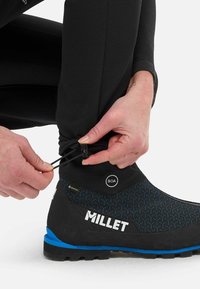 Botte imperméable noire avec accents bleus, surface texturée et système de laçage BOA. Logo en vedette : "MILLET" affiché de manière proéminente.