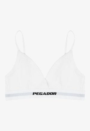 Balts bralette ar trīsstūrveida kausiņiem, regulējamām lencēm un plašu elastīgu joslu, uz kuras ir uzraksts "PEGADOR" treknajos melnajos burtos.