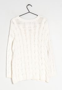 Pull en tricot blanc avec un motif en relief, encolure ronde et manches longues. Le tissu texturé présente un ourlet et des poignets côtelés, suspendu à un crochet noir.