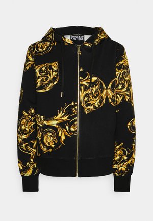 Zwarte hoodie met ritssluiting, gouden barokke bloempatronen, trekkoordkap en label "Versace Jeans Couture" aan de binnenkant van de kraag.