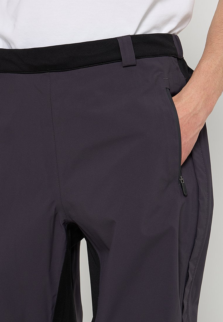 Donkerpaarse herenbroek met een gladde textuur, voorzien van een zwarte tailleband, zijzakken met ritsen en een tapere pasvorm.