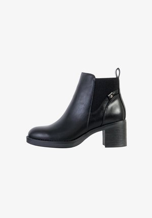 Bottes noires à la cheville en simili cuir avec un côté élastique rayé. Bout rond, talon carré et une languette à l'arrière.