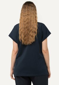 Camiseta de manga corta azul marino con un corte relajado, dobladillo redondeado y textura suave. La vista trasera resalta la caída y la simplicidad del diseño.