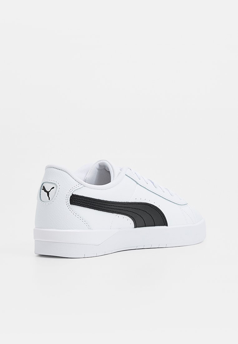 Sneaker bianco in pelle sintetica con un design a strisce nere, linguetta imbottita e suola testurizzata per una migliore aderenza.