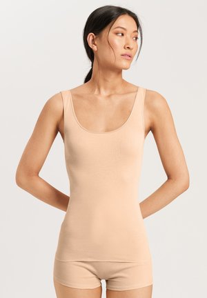 Nude tanktop med en rund halsudskæring, glat tekstur og brede stropper. Pasformen er tætsiddende med en subtil glans. Simpelt design.