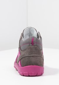 Kinderschoen in grijs suede met roze accenten. Beschikt over een stevige, gestructureerde zool en een gevoerd kraagje voor extra steun.