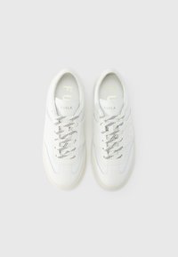 Hvite skinnsneakers med glatt tekstur, med svarte snorer med prikker og subtile blå detaljer, merket "FURLA" i gull på tungen.