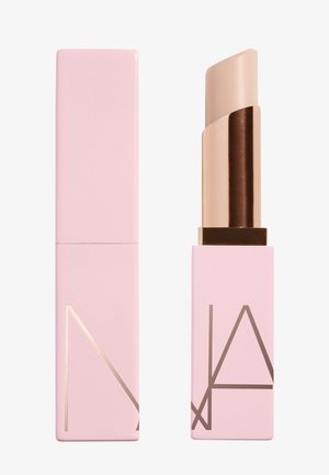Tube de rouge à lèvres rose clair avec un bouchon assorti, un fermé et un ouvert montrant un rouge à lèvres beige à l'intérieur, design simple et moderne avec des lettres angulaires.