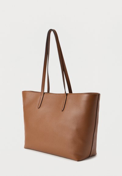 Sac cabas en cuir marron avec une surface texturée, deux longues poignées et un design minimaliste. Aucun matériel visible ni motifs.