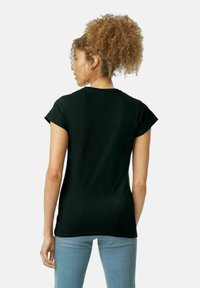 Svart bomull t-shirt med korta ärmar, rund halsringning och en figurnära design, sedd bakifrån, tillsammans med ljusblå jeans.