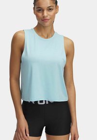 Lichtblauw mouwloos crop top van een glad materiaal, gecombineerd met zwarte shorts met een witte logo band op de taille.