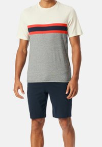 Grijze T-shirt met korte mouwen, voorzien van een crèmekleurig, rood en marineblauw gestreept horizontaal patroon. Gecombineerd met marineblauwe shorts voor een casual uitstraling.