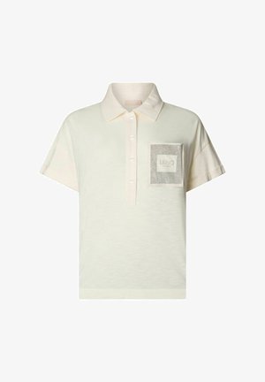 Polo de color crema con mangas cortas, que presenta una tapeta con botones y un bolsillo texturizado con detalle de logo en el pecho izquierdo.