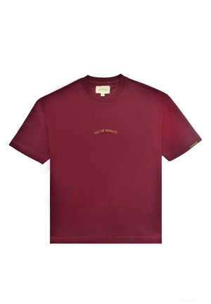 Burgundia puuvillane T-särgid, millel on ümmargune kaelus ja lühikesed varrukad. Esiküljel keskosas on kullavärvi broderi "PAS DE MONACO".