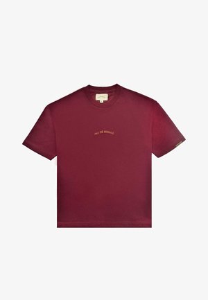 Burgundia puuvillane T-särgid, millel on ümmargune kaelus ja lühikesed varrukad. Esiküljel keskosas on kullavärvi broderi "PAS DE MONACO".