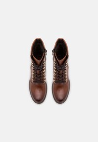 Bottines en cuir marron avec une finition lisse, œillets dorés, lacets noirs et fermetures éclair latérales. Dotées d'un col rembourré pour plus de confort.