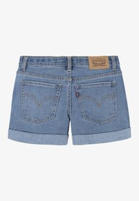 Shorts en denim bleu clair, avec un ourlet replié, deux poches arrière avec une couture courbée, et une étiquette de marque en cuir marron sur la ceinture.