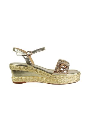 Sandalo wedge di colore oro metallico con suola in juta intrecciata e fascetta decorata con strass, dotato di un sottile cinturino alla caviglia e design a piattaforma.