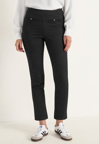 Svarta denimbyxor med hög midja, som har framfickor och subtila detaljer i metall. Passformen är smal genom benet.