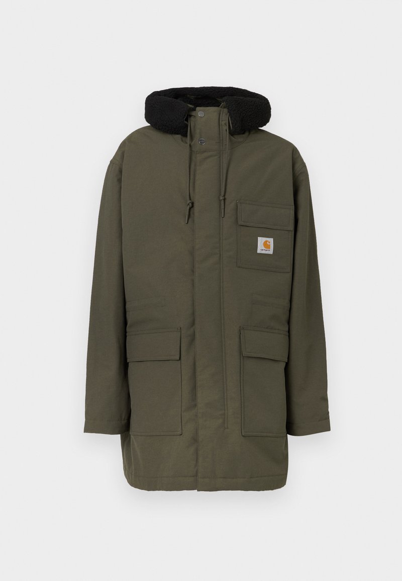 Parka verde oliva con cappuccio foderato in fleece nero, dotata di zip frontale, due ampie tasche a pattina e una tasca sul petto con patch logo.