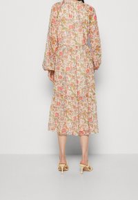 Robe midi fleurie en tissu léger et transparent ; comprend des manches longues, une taille élastique, un ourlet à volants ; couleurs disponibles : rose, jaune et vert.